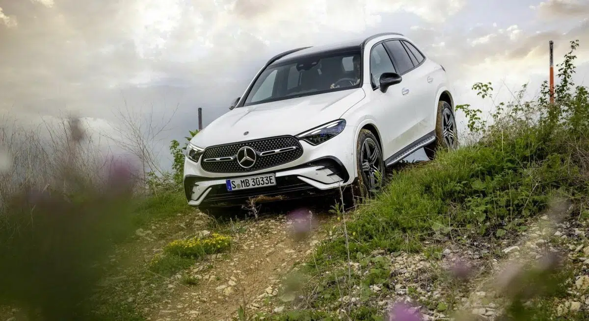 Le Mercedes-Benz GLC hybride rechargeable en train de franchir un terrain difficile, démontrant ses capacités tout-terrain.