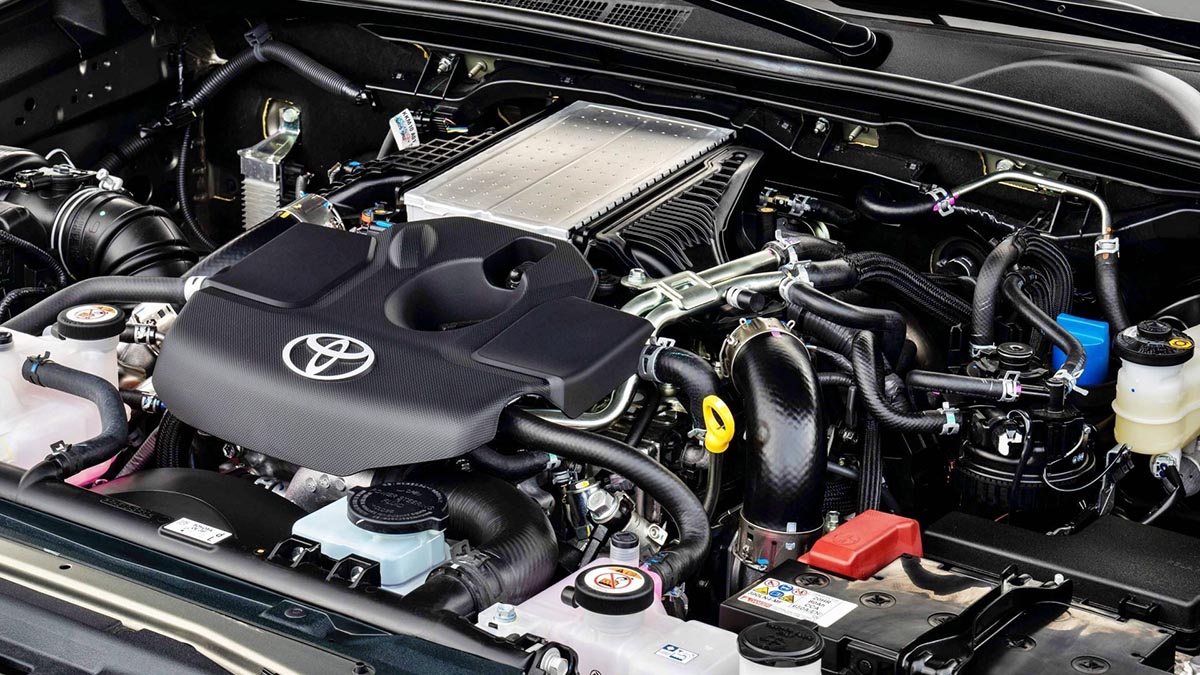 Moteur Toyota hybride ECO monté sur Hilux, avec ses caches moteur spécifiques et son système d'admission visible.