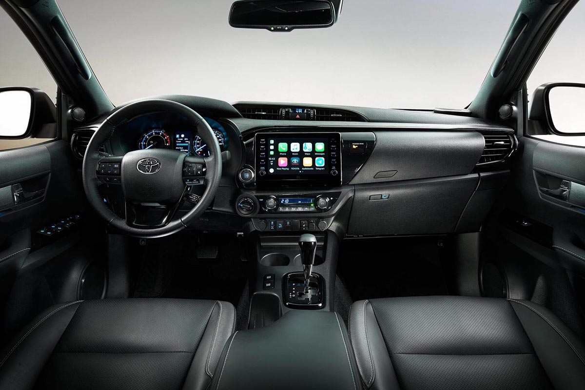 Cockpit du Hilux montrant le tableau de bord, les commandes tout-terrain et l'écran multimédia.