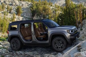Nouveau tout-terrain photographié en action sur terrain accidenté, montrant ses angles d'attaque généreux et sa garde au sol comparable au Wrangler, avec une silhouette distinctive