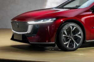 La nouvelle Mazda 6e électrique photographiée de trois-quarts avant, mettant en valeur sa silhouette élégante de berline et ses attributs distinctifs de version électrique.