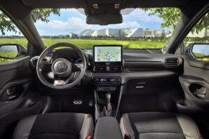 La Toyota Yaris hybride vue de profil, mettant en évidence son design compact et aérodynamique avec des éléments visuels soulignant sa motorisation hybride ultra-efficiente
