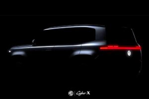 Teaser du SUV électrique MG Cyber X montrant partiellement sa silhouette aux lignes futuristes et sa signature lumineuse distinctive dans un environnement ombré, annonçant les ambitions du constructeur chinois.