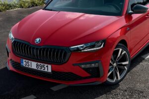 Skoda Scala Monte Carlo 2025 de couleur rouge sur route de montagne, montrant sa silhouette sportive et dynamique avec jantes alliage spécifiques et détails noirs distinctifs de la finition Monte Carlo.
