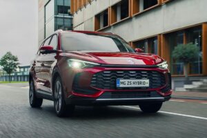 MG ZS Hybrid+ 2025 en situation urbaine avec coffre ouvert, illustrant son volume de chargement de 443 litres et son positionnement accessible
