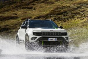 Jeep Avenger 4xe 2025 en finition Upland stationné sur chemin forestier, profil dynamique en pleine nature
