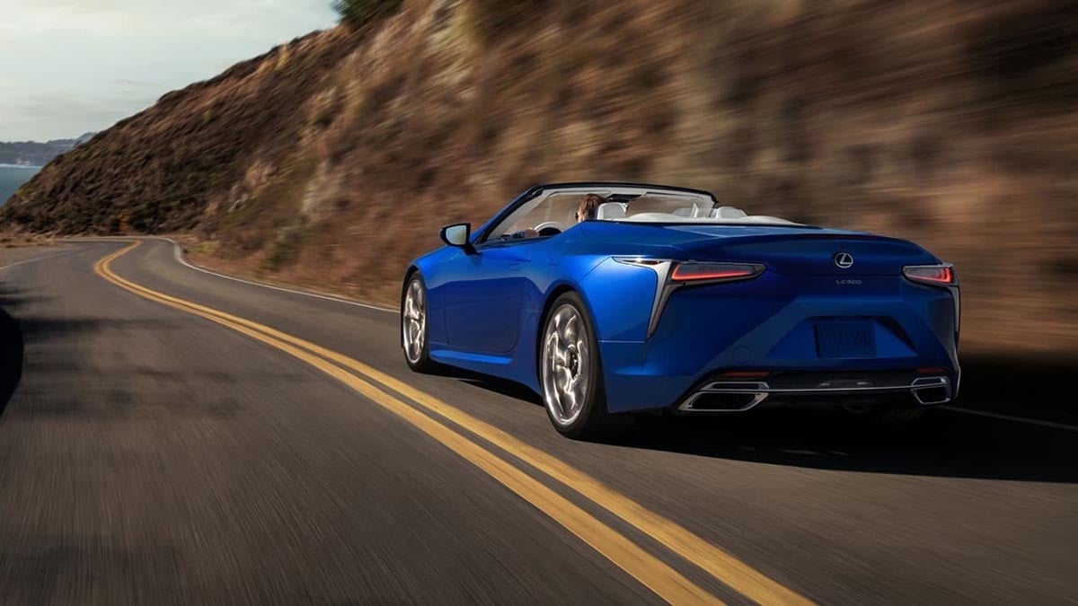 Lexus LC 500 h cabriolet vue de dos roulant sur une route côtière en été