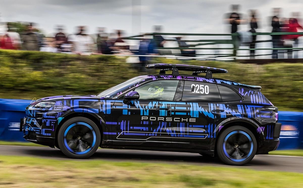 Porsche Cayenne 2026 électrique de profil sur une route en montée lors d’une course