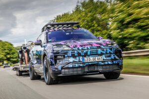 Véhicule tout-terrain iconique rénové en action sur route avec une remorque