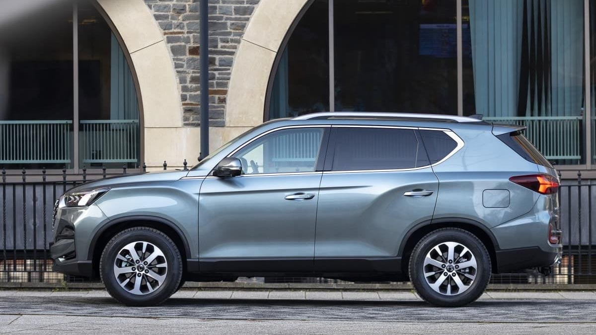 Vue latérale du KGM Rexton 2025 gris sur route, grand SUV 7 places à transmission intégrale