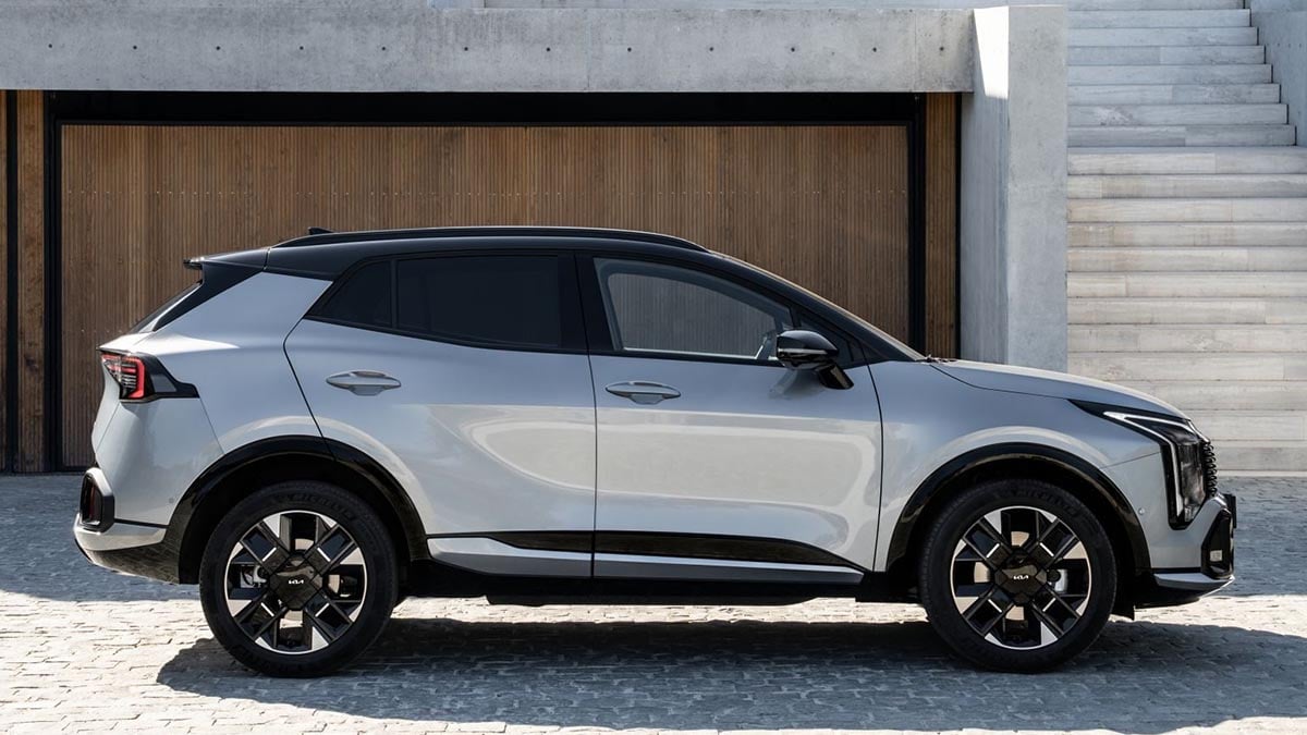 Kia Sportage 2025 restylé en finition hybride, stationné sur route panoramique