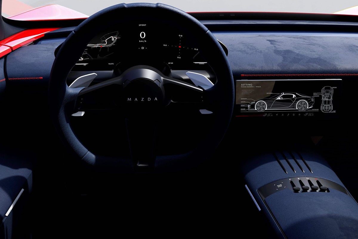 Gros plan sur le cockpit du Mazda RX-9 avec volant sport et instrumentation numérique minimaliste.
