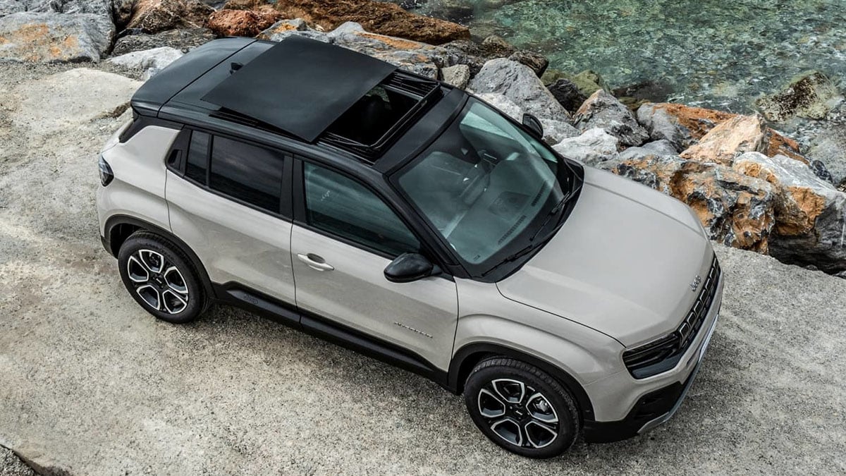 Vue latérale du Jeep Avenger e-Hybrid blanc stationné sur route urbaine