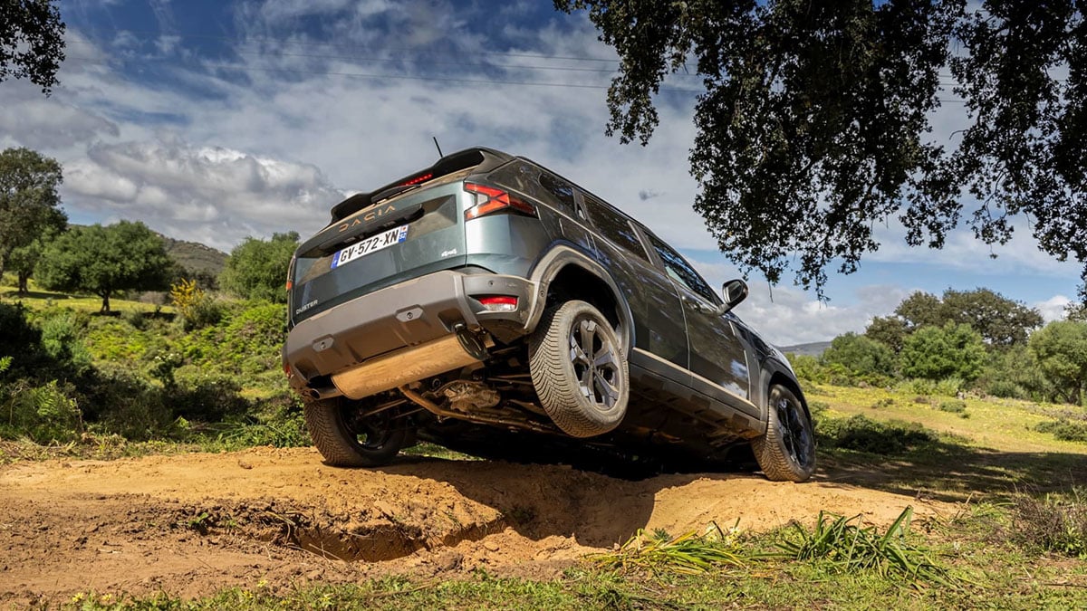 Vue arrière du Duster mild hybrid 4x4 en descente sur terrain accidenté